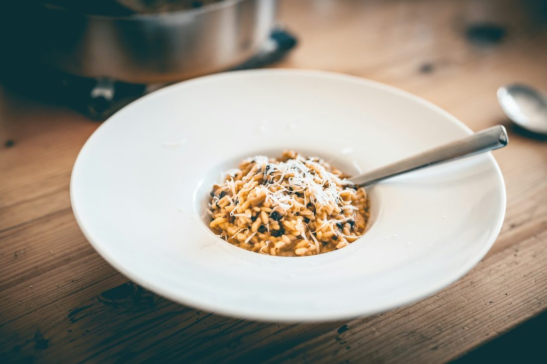 Risoto de alho-poró com parmesão em prato branco